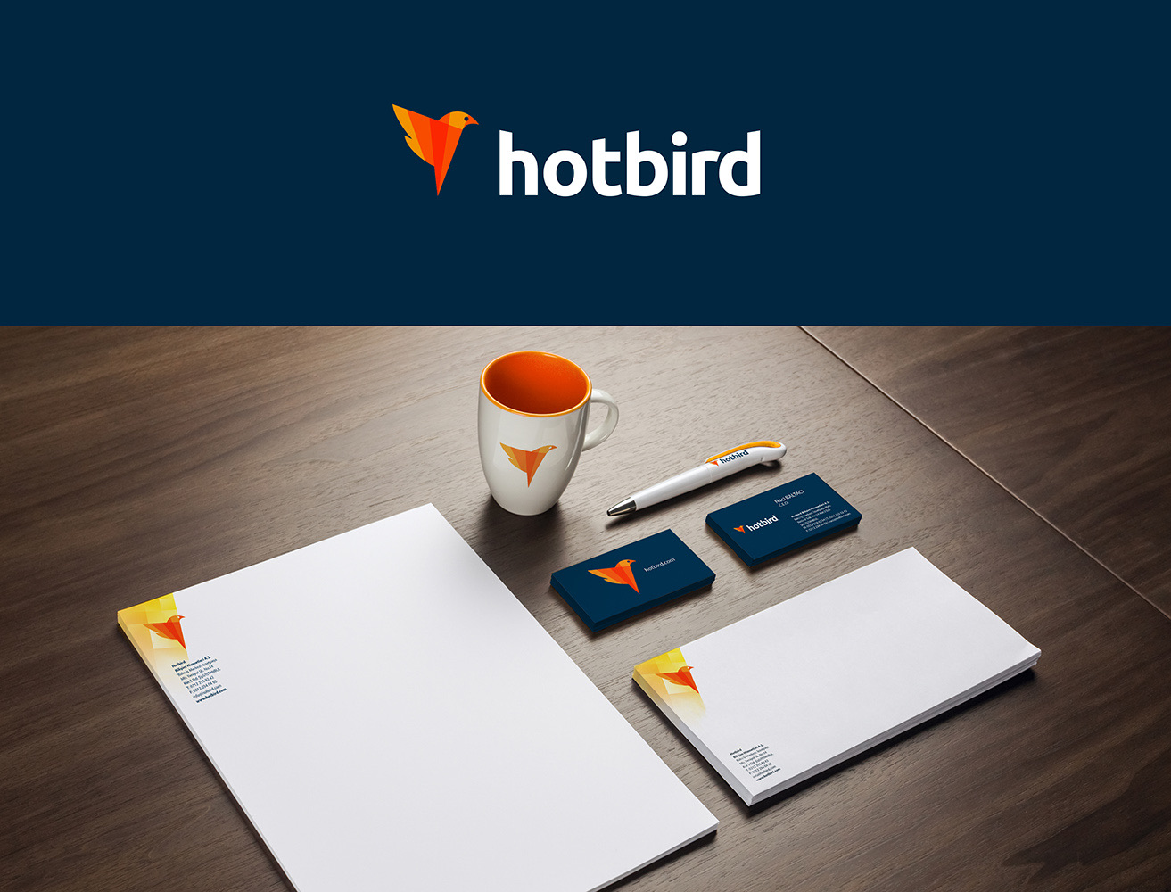 Hotbird stationery on a desk: cards, letterhead, mug and pen