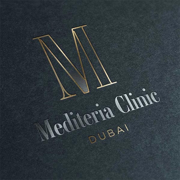 The Mediteria Clinic logo in gold foil on dark paper